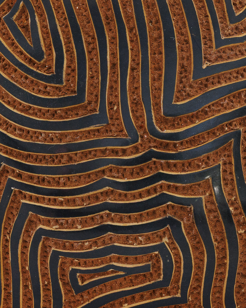 Amaru: handmade Nicaraguan ceramic rounded terracotta vessel carved with concentric maze-like lines and a black glazed neck, close-up of the carved texture