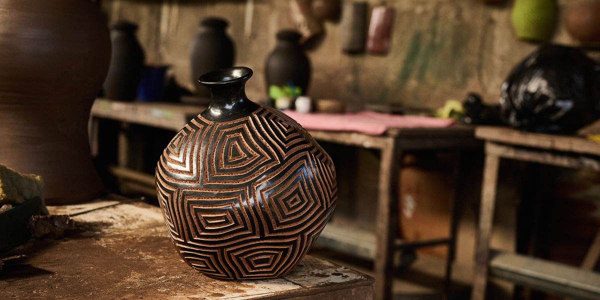 Hand-carved ceramic vessel with a geometric maze pattern in a Nicaraguan pottery workshop