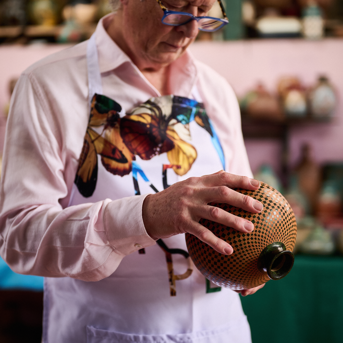 An artisan painting fine detail onto a patterned ceramic vessel