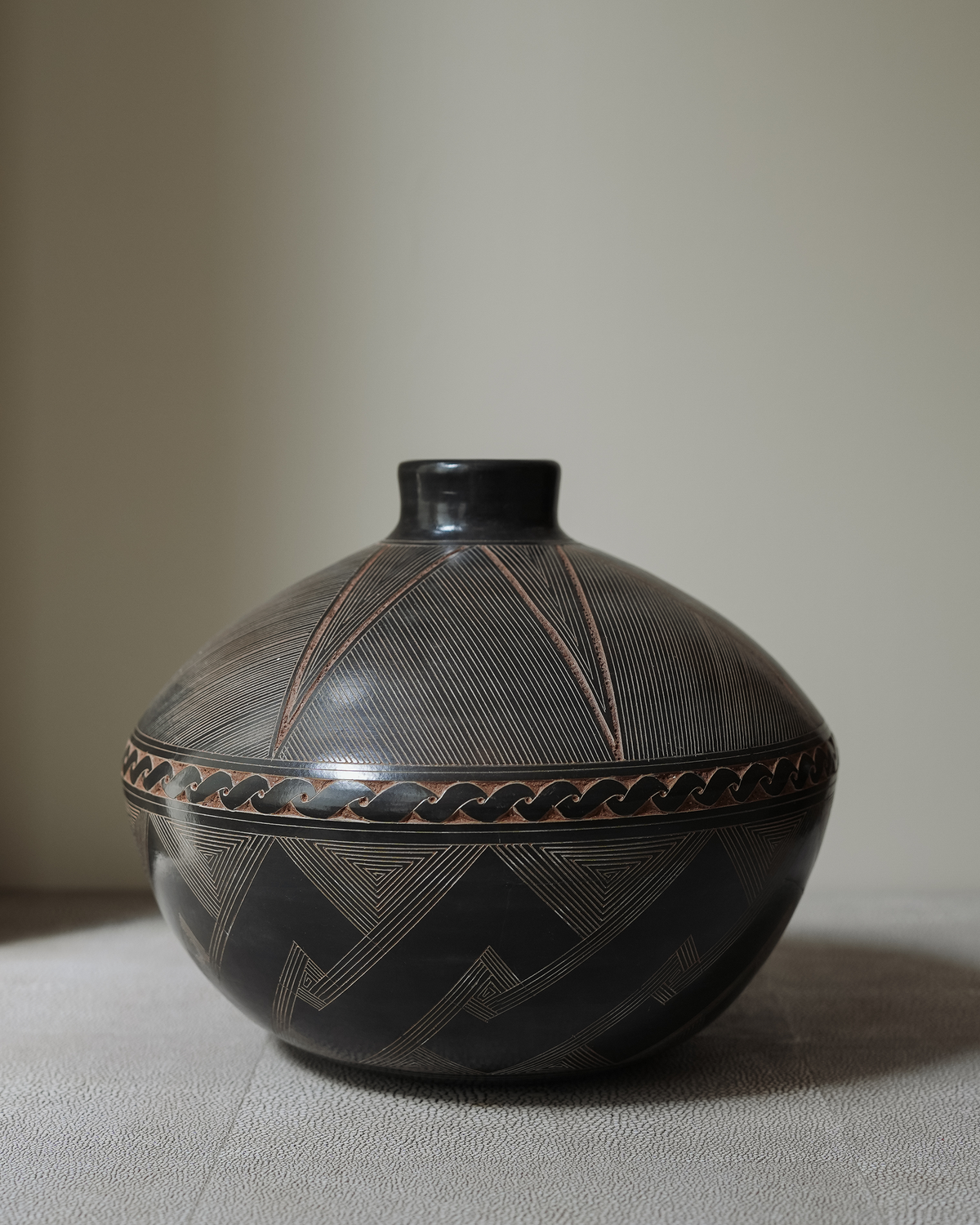 Cerezo: handmade Nicaraguan ceramic dark grey vessel with an incised geometric band and zigzag pattern
