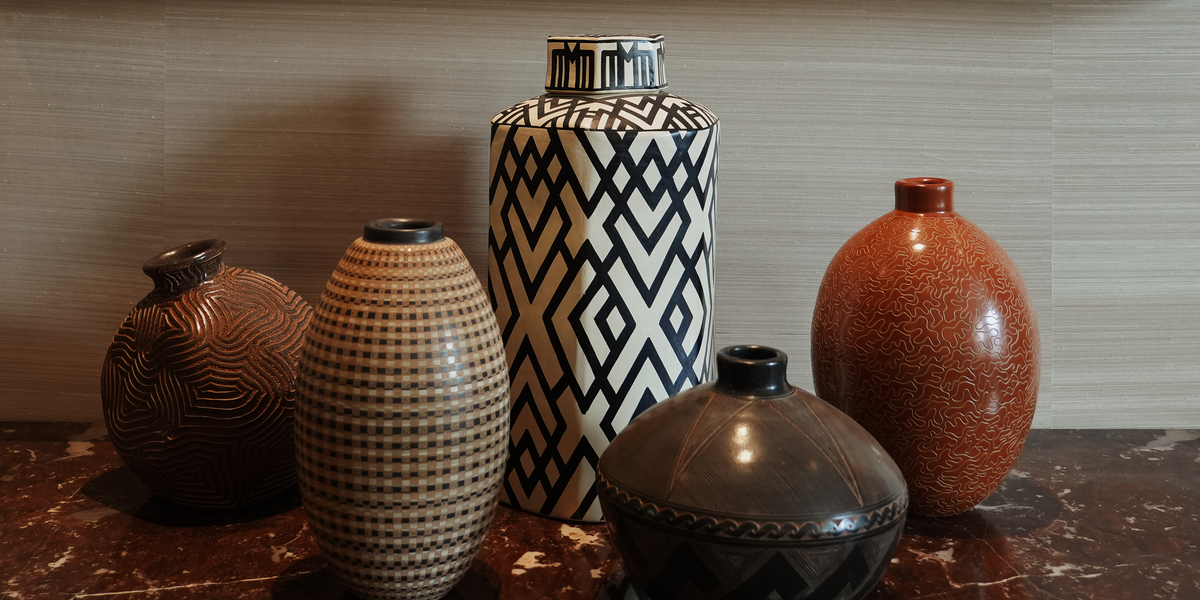 A group of Siddeley Ceramics vessels on a marble-topped dresser