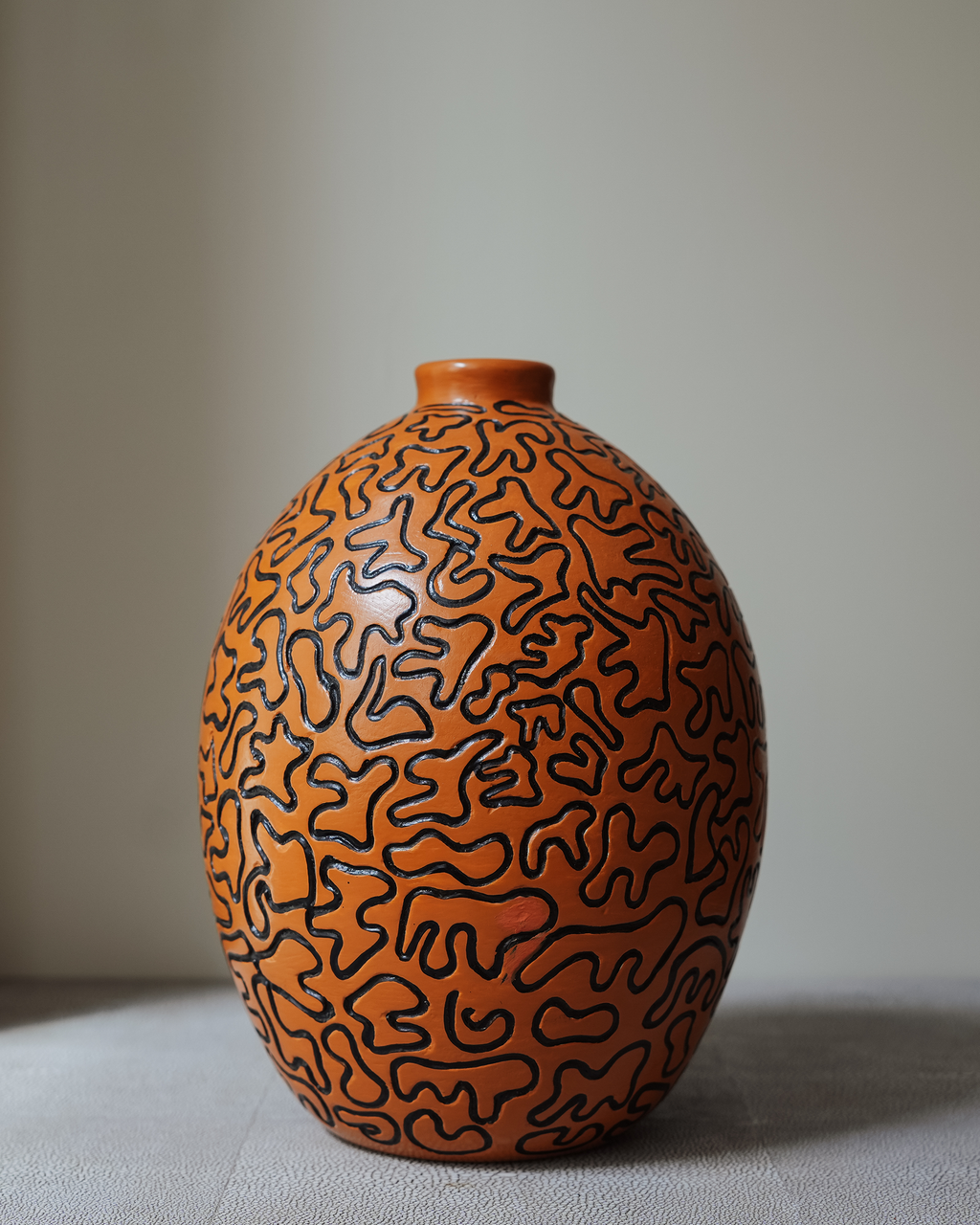 Hortensia: handmade Nicaraguan ceramic oval orange vessel with a meandering black line pattern