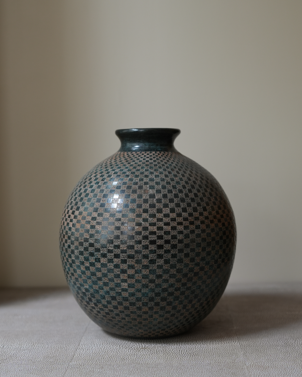Lunaro: handmade Nicaraguan ceramic round grey-green vessel with a fine carved chequered pattern