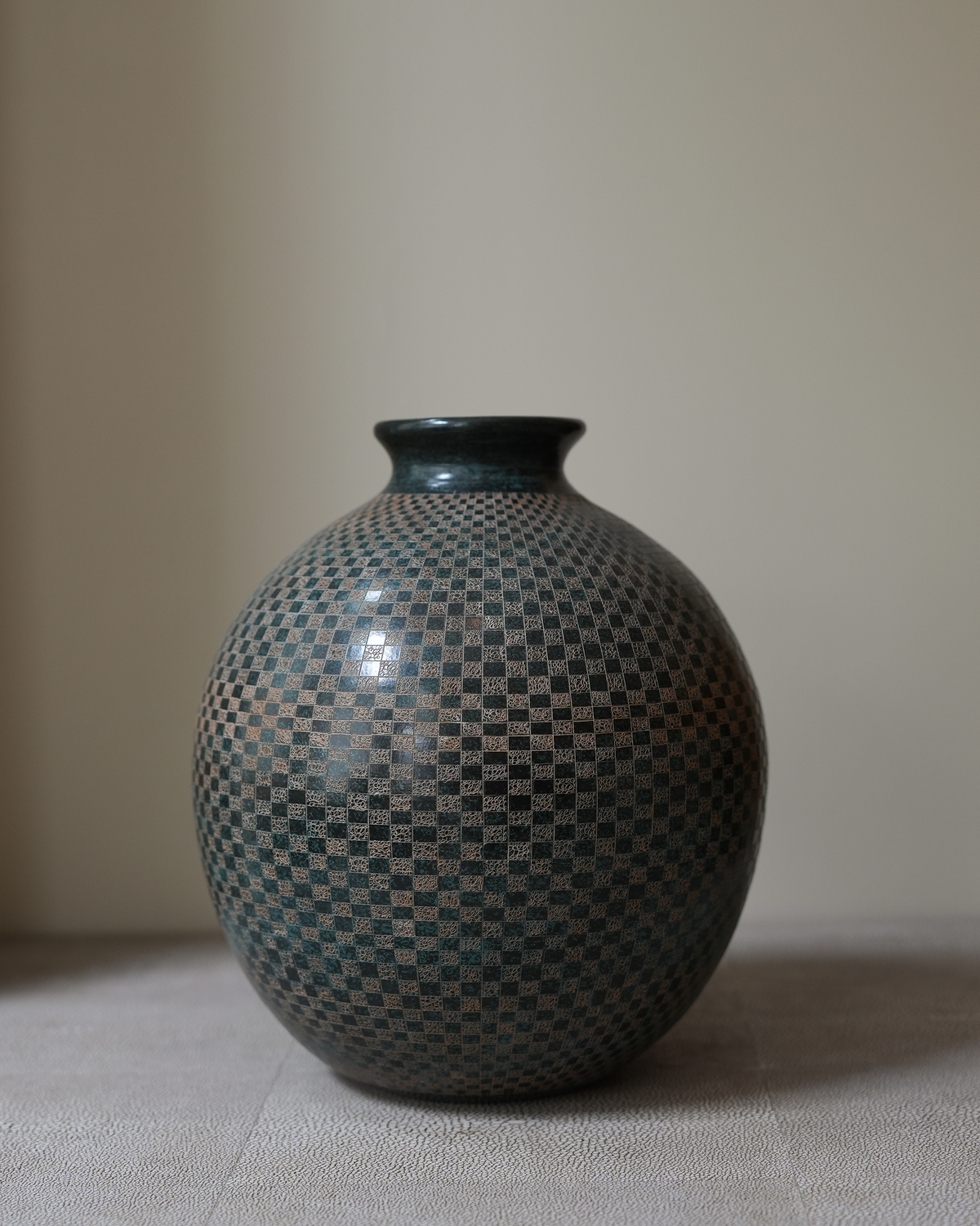 Lunaro: handmade Nicaraguan ceramic round grey-green vessel with a fine carved chequered pattern