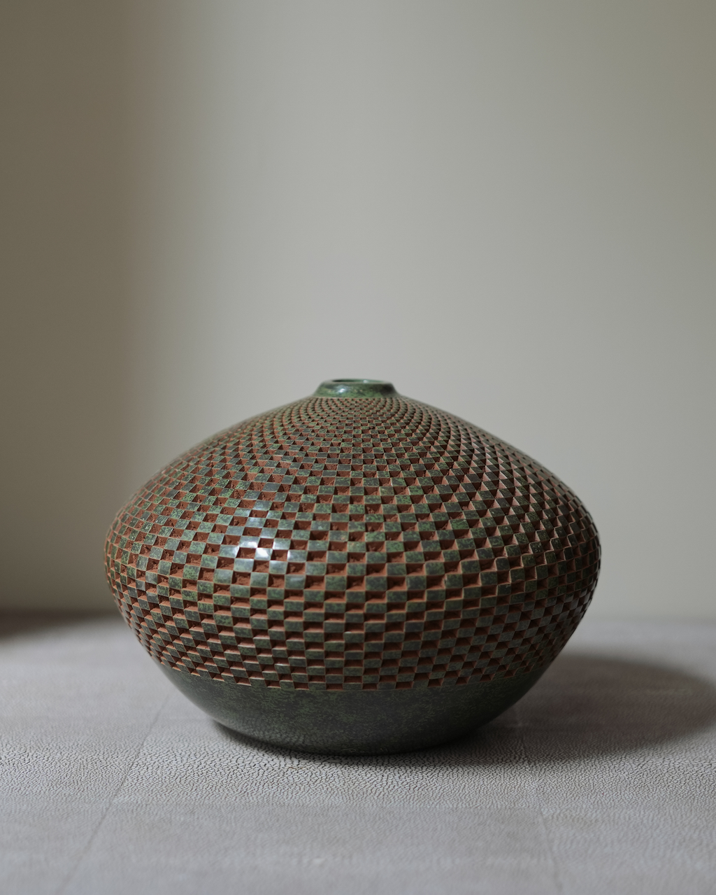 Mistral: handmade Nicaraguan ceramic squat round vessel with a carved honeycomb pattern in terracotta and grey-green