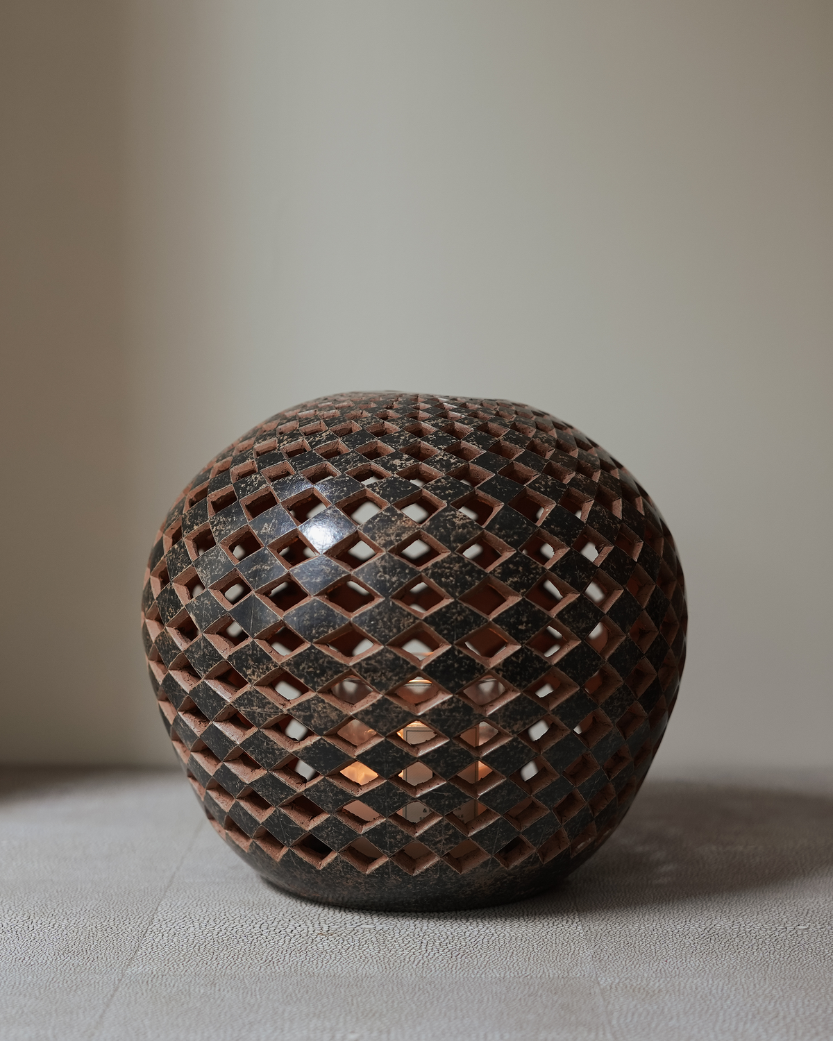 Solandra: handmade Nicaraguan ceramic round vessel with a carved diamond lattice in terracotta and black